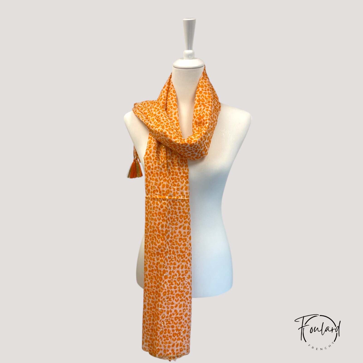 Détail des pompons bohèmes sur le foulard en coton