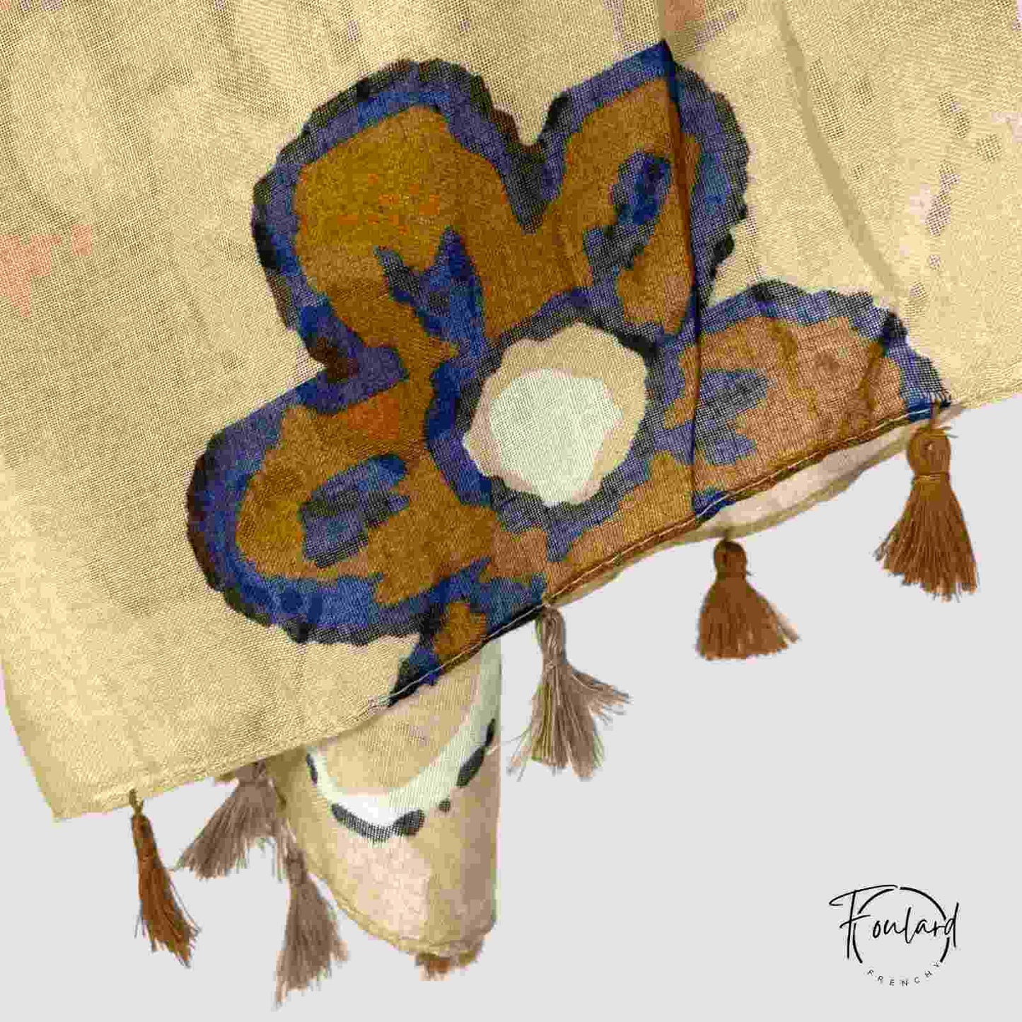 Foulard beige noué, mettant en valeur les motifs