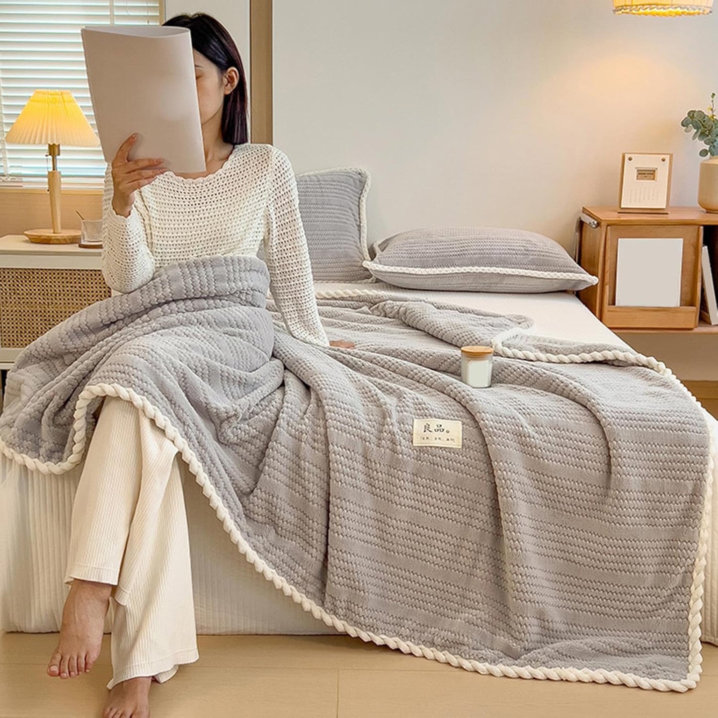 Plaid gris en pilou pilou sur un canapé cosy