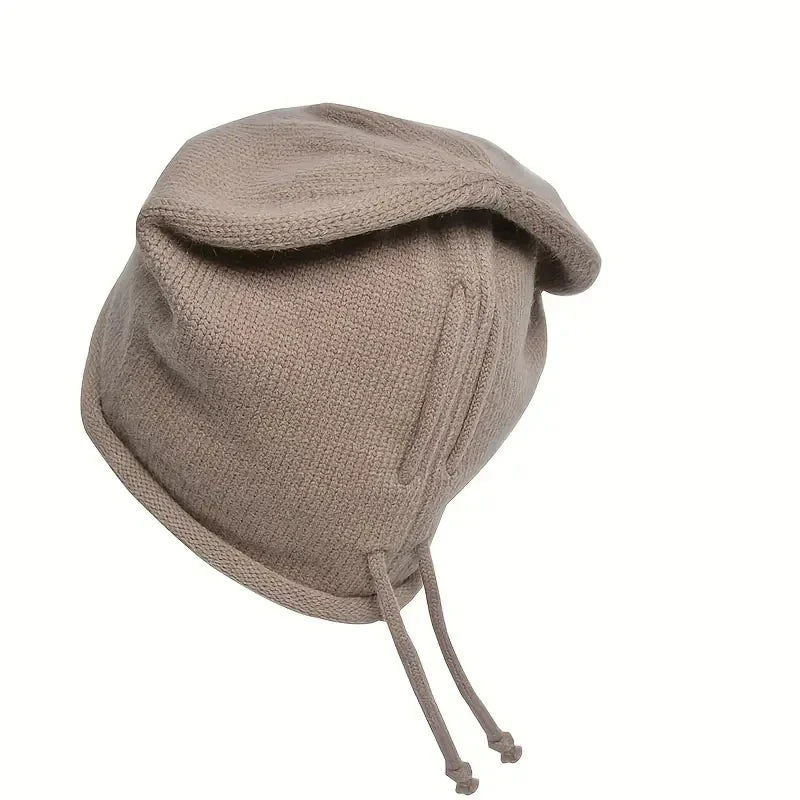 Bonnet oversize posé sur une table en bois clair
