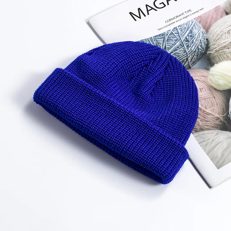 Bonnet tricoté gris, posé à plat, montrant sa texture