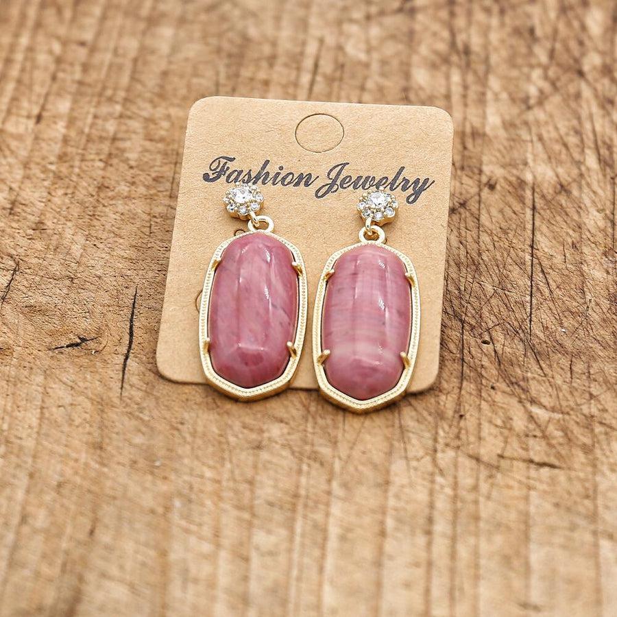 Boucles d'oreilles dorées montrant la taille des perles centrales