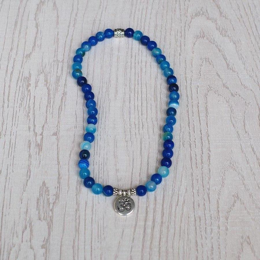 Détail du bracelet en onyx bleu avec charme Bouddha