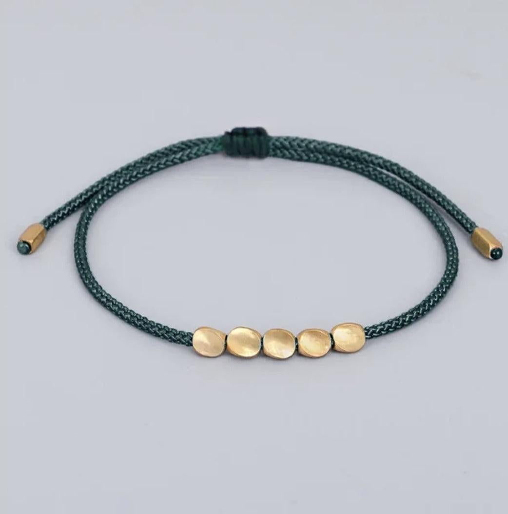 Bracelet tibétain en cuivre avec perles, présenté enroulé