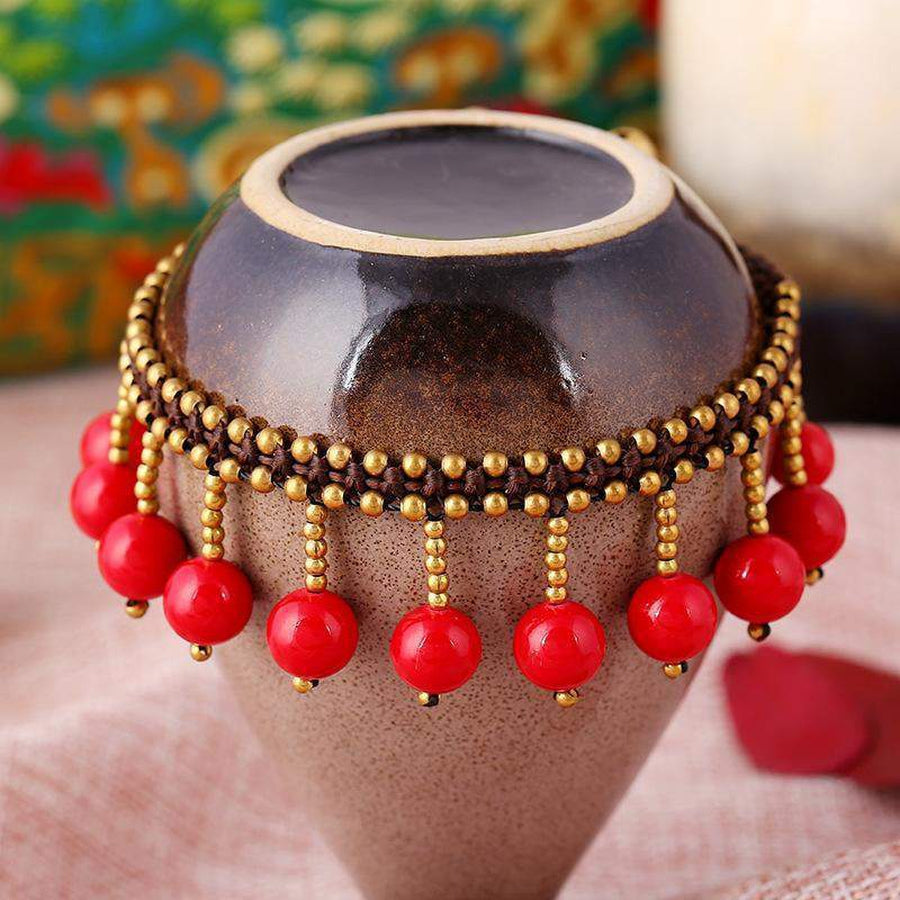 Gros plan sur les perles de corail rouge du bracelet