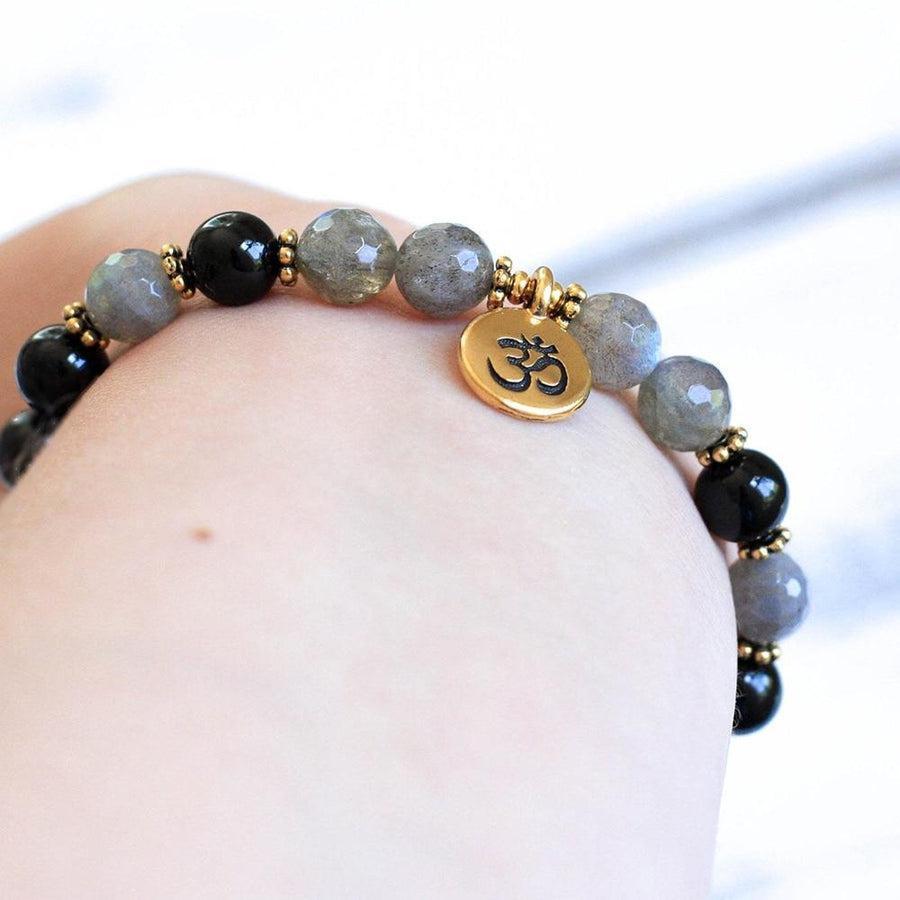 Détail du charme doré avec symbole Om sur le bracelet
