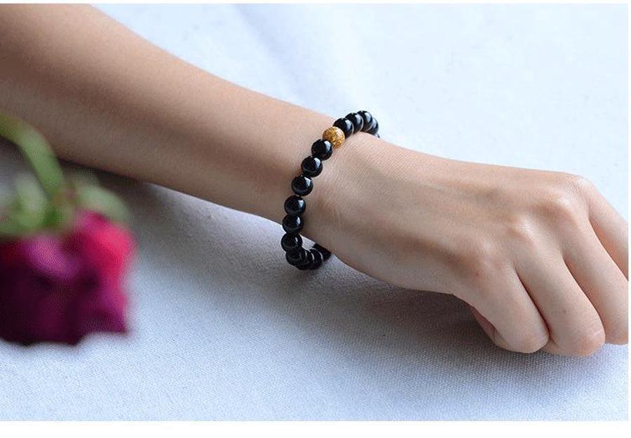 Bracelet élégant en onyx noir posé sur une surface claire