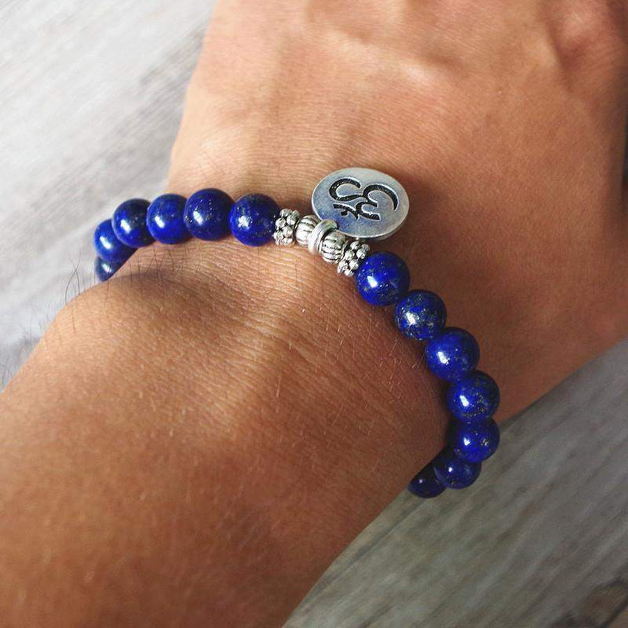 Gros plan sur perles bleues et pendentif Om