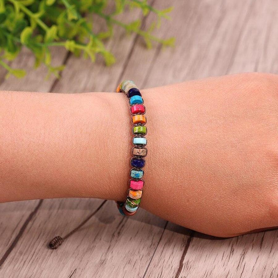 Bracelet chakras posé sur une surface en bois clair
