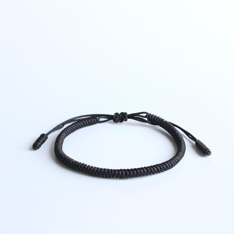 Détail des mantras tressés sur le bracelet noir