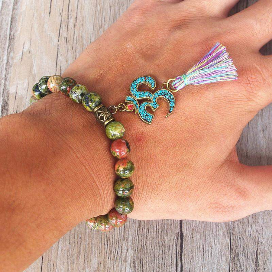 Vue latérale du bracelet tibétain en Unakite avec charme Om
