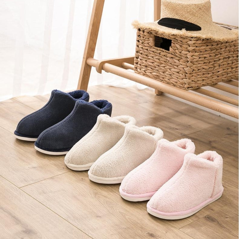 Chaussons rose pastel posés sur un parquet en bois