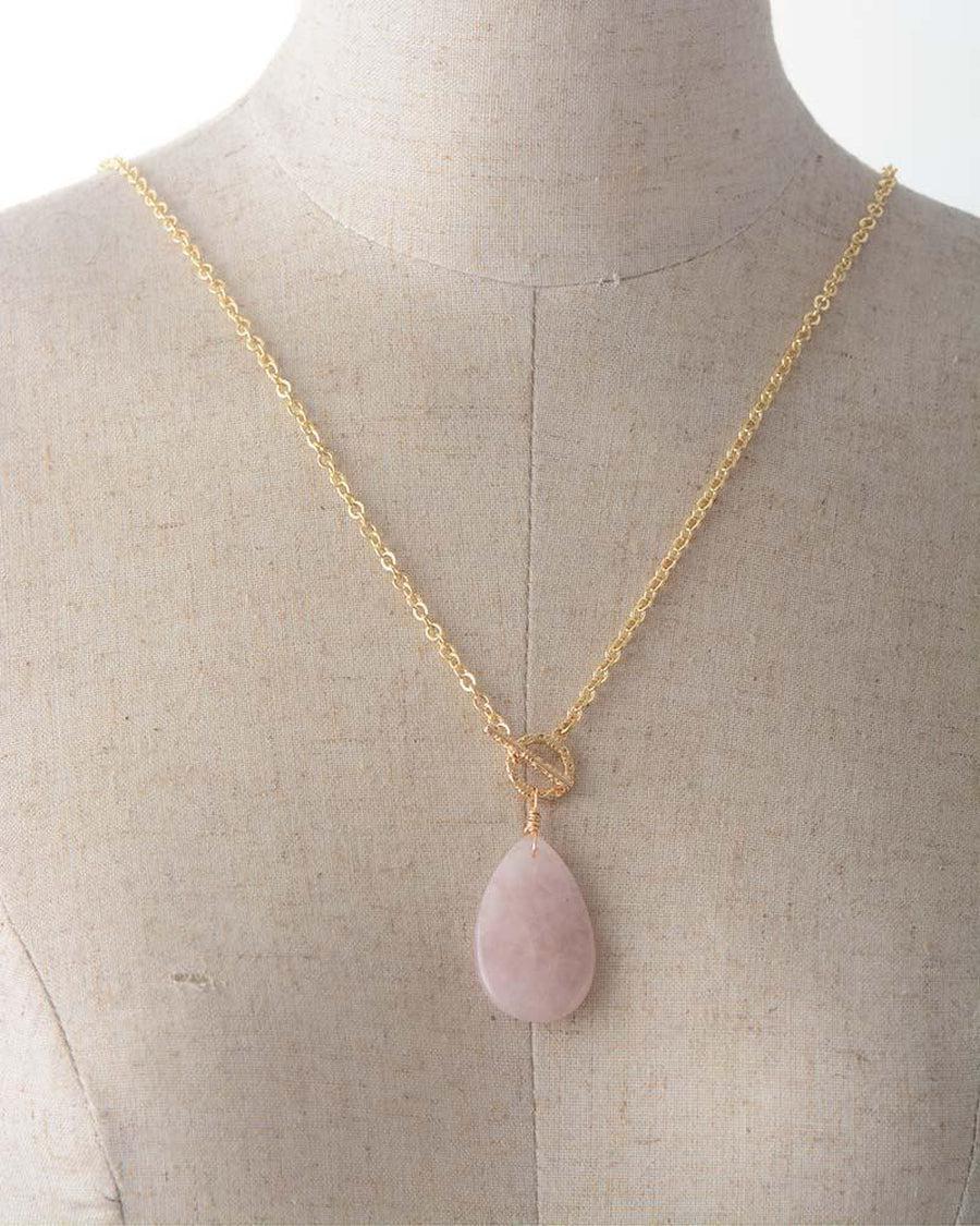 Collier quartz rose sur fond neutre, mettant en valeur le pendentif