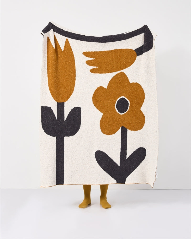 Couverture étalée sur un lit, mettant en valeur le design floral