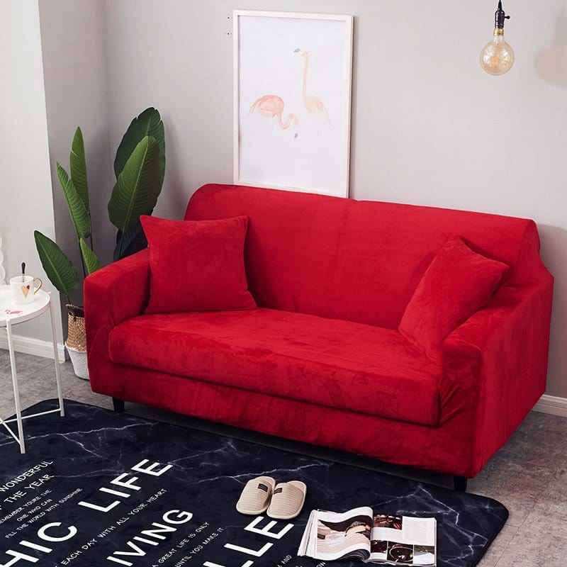 Housse extensible rouge couvrant un canapé d'angle