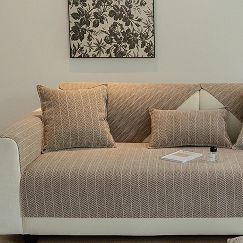 Housse de coussin beige taupe en tissu herringbone sur canapé