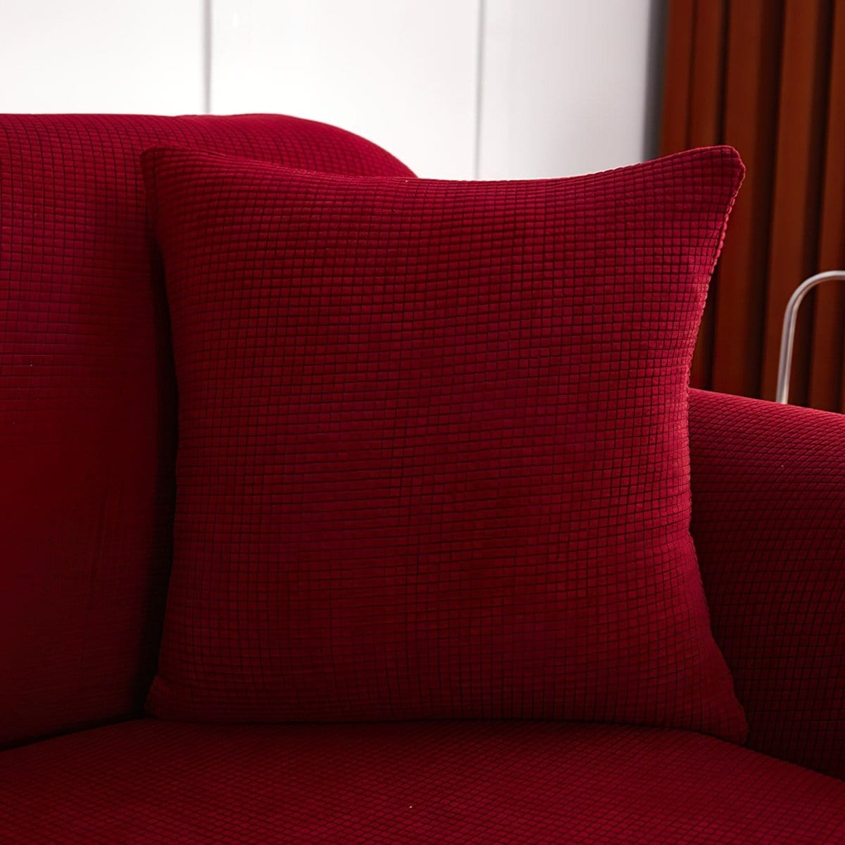 Housse de coussin bordeaux sur canapé moderne, tissu déperlant