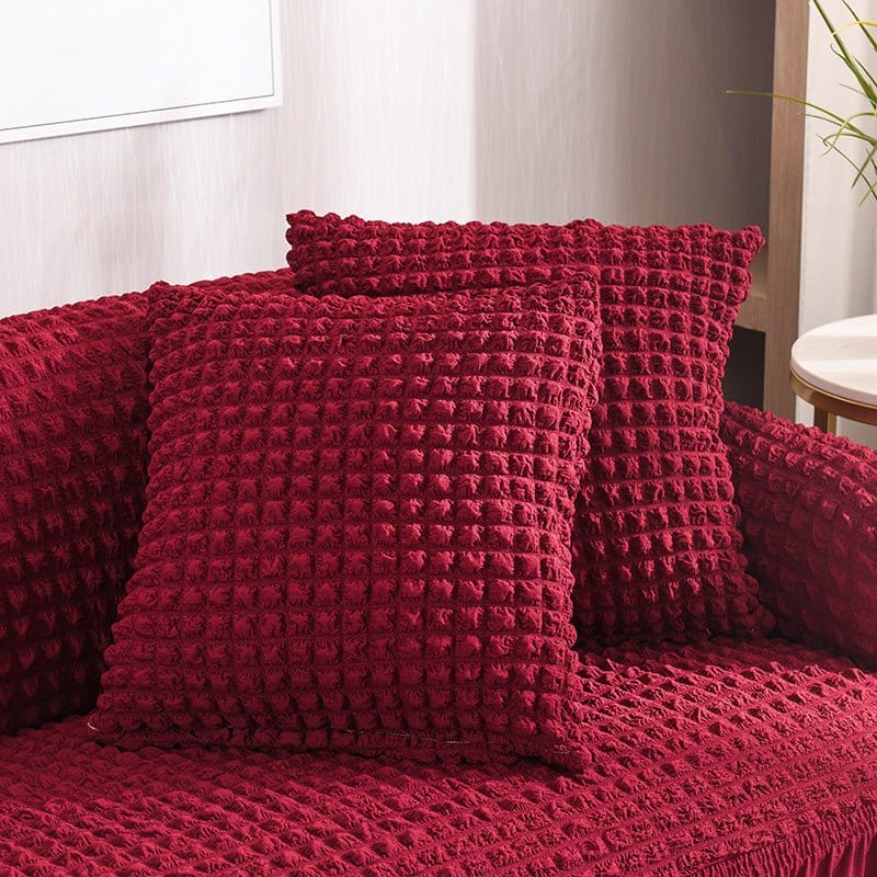 Deux housses de coussin bordeaux extensibles sur canapé moderne