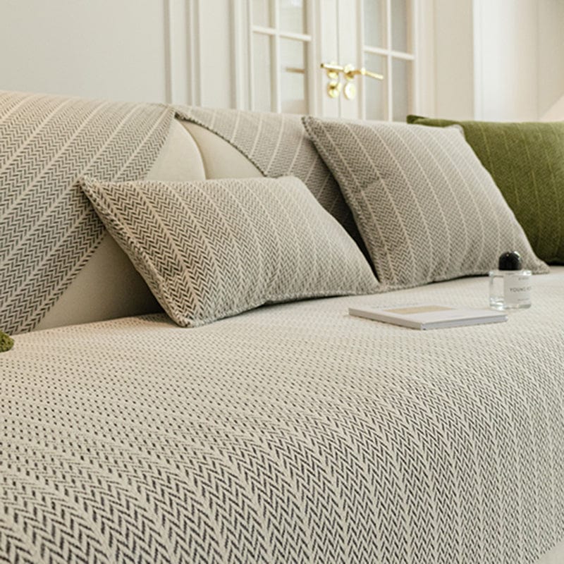 Housse de coussin gris en tissu herringbone sur canapé
