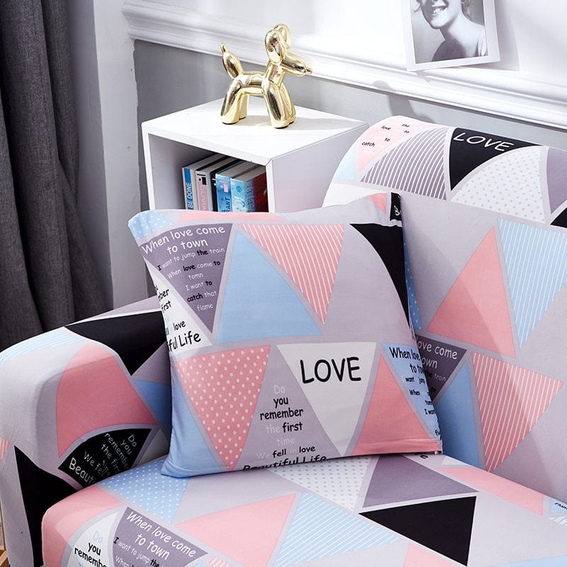 Deux housses de coussin roses extensibles sur canapé gris