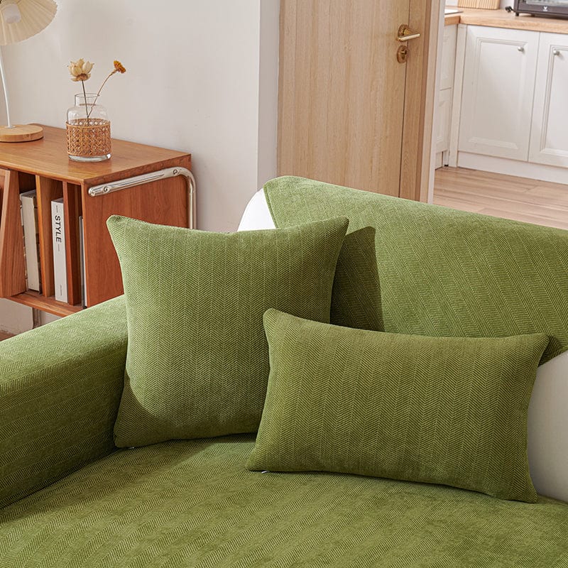 Housse de coussin verte en tissu chenillé sur canapé