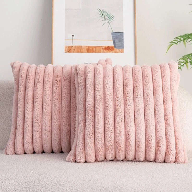 Housse de coussin rose en polaire matelassée sur canapé