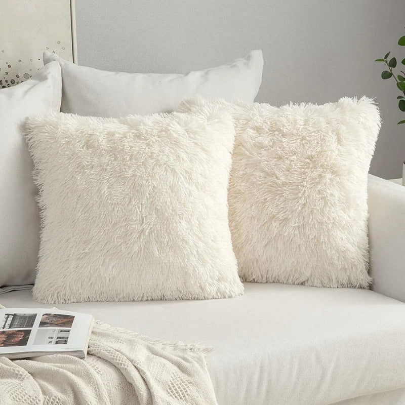 Housse de coussin blanche en moumoute sur canapé