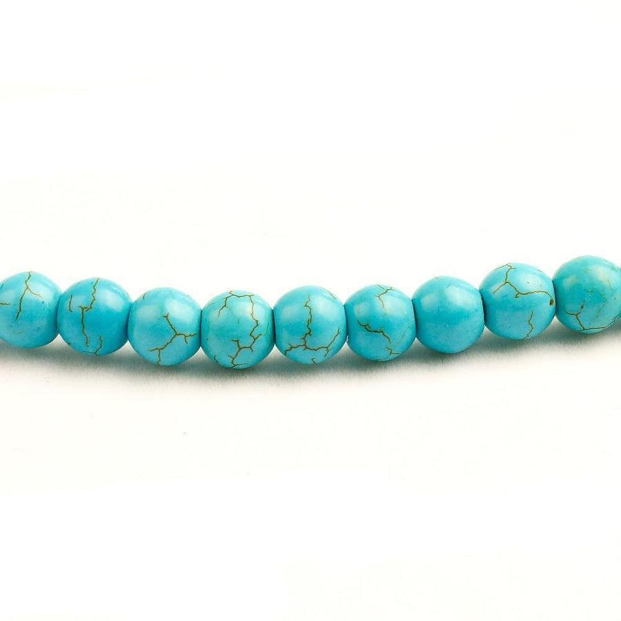 Mala turquoise posé sur une surface en bois clair