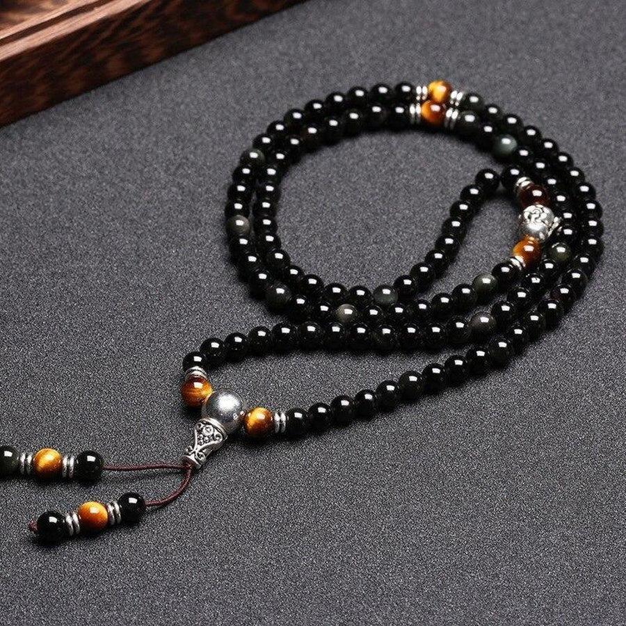 Gros plan sur les perles d'obsidienne et œil de tigre du mala