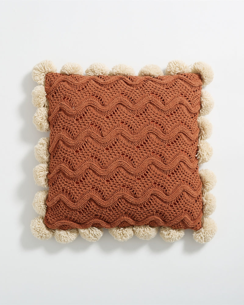 Vue de côté de l'oreiller avec motifs vagues et pompons