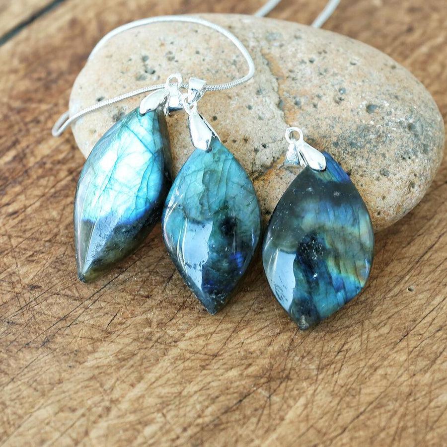 Pendentif en labradorite avec reflets irisés sur fond blanc