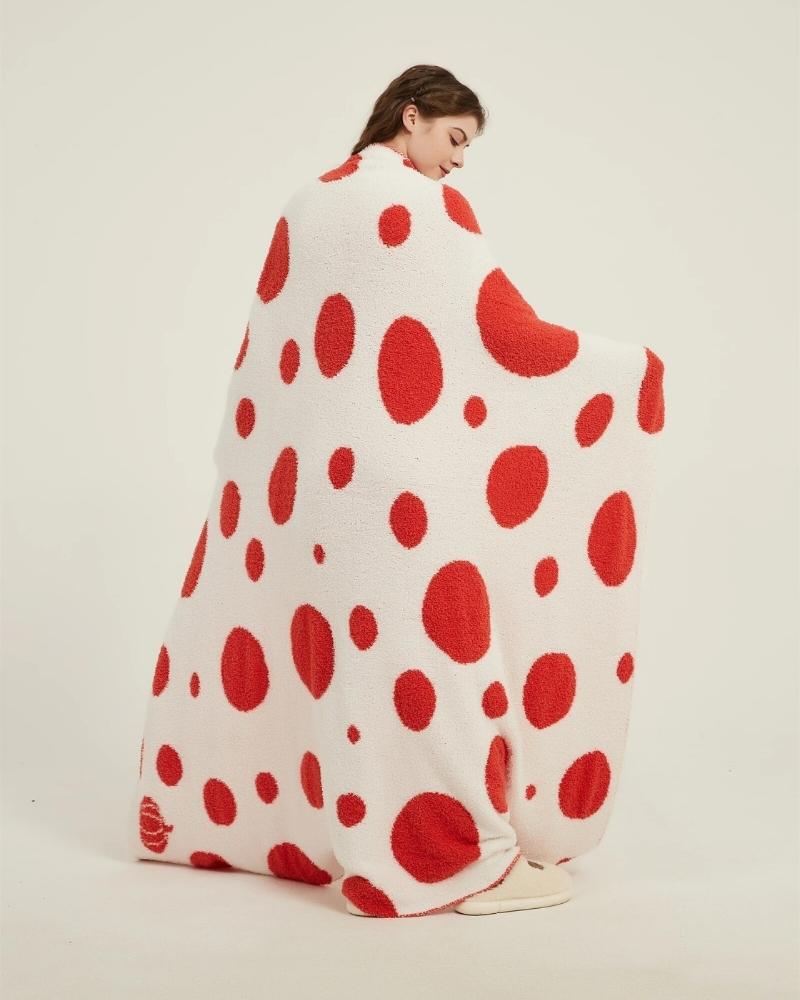 Vue d'ensemble du plaid rouge à pois blancs sur lit