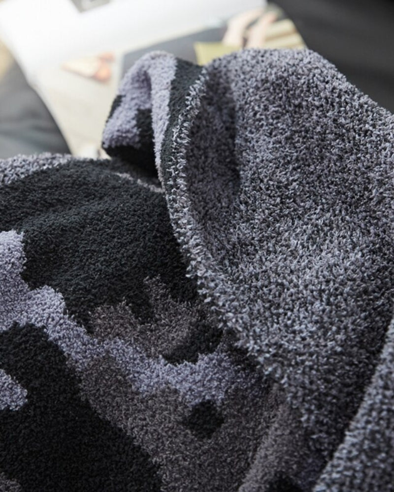 Plaid noir drapé sur un fauteuil en intérieur élégant