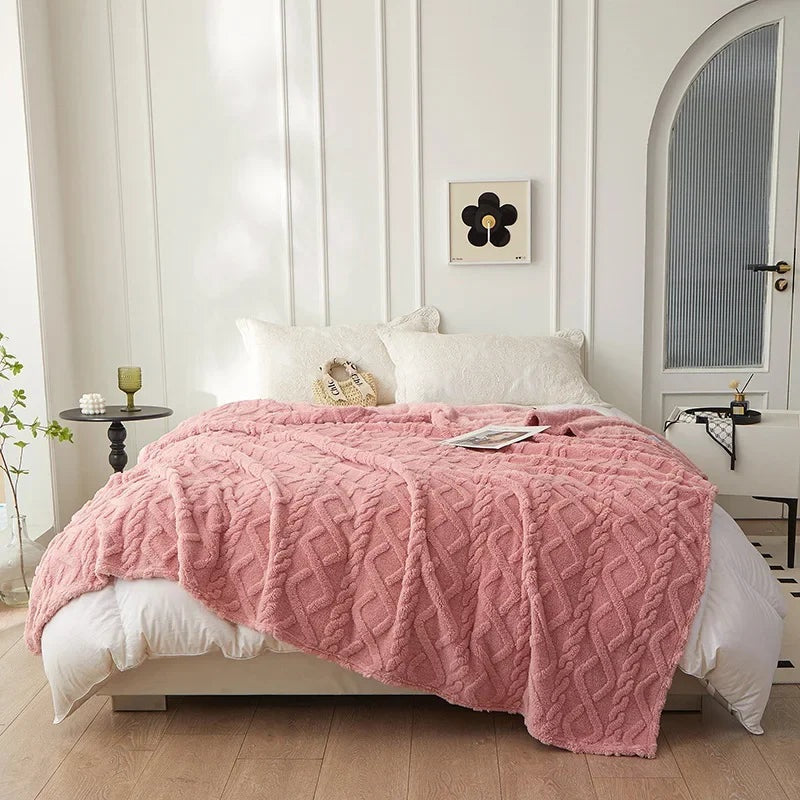 Plaid rose torsadé en Pilou Pilou sur un canapé