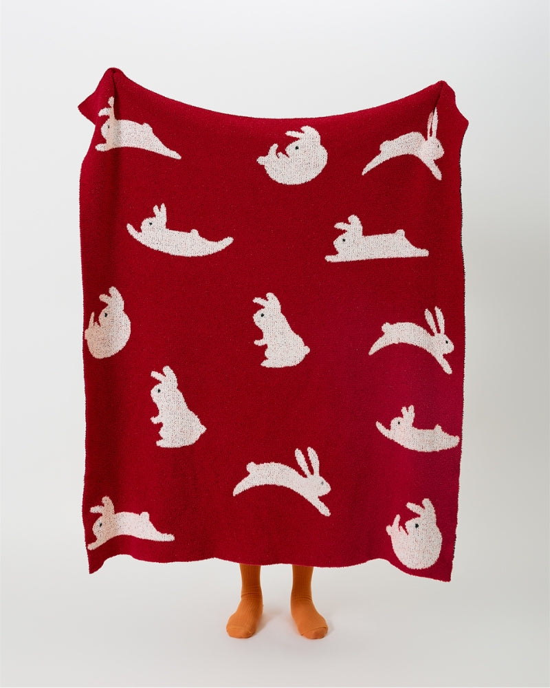 Détail des motifs animaliers blancs sur le plaid rouge