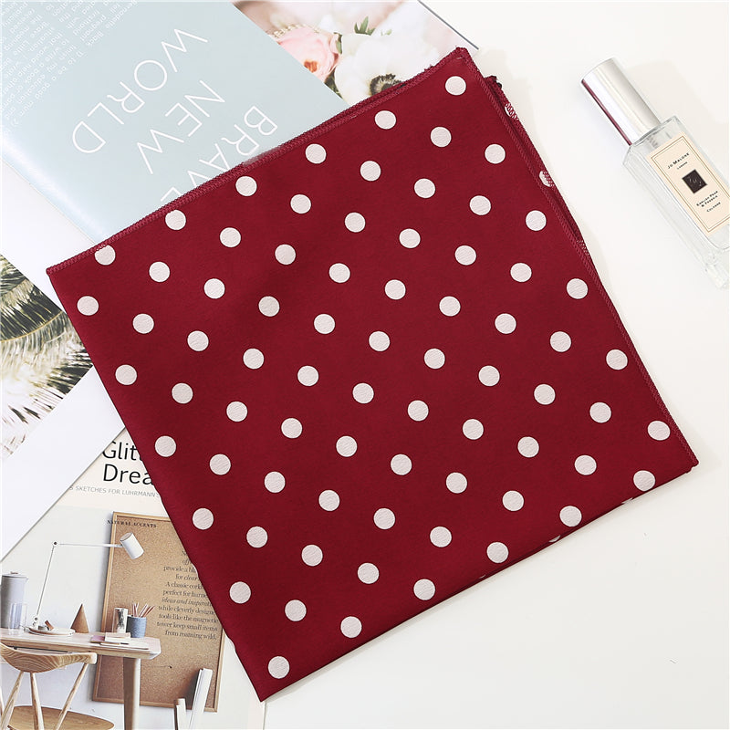 Foulard rouge à pois posé sur une surface blanche