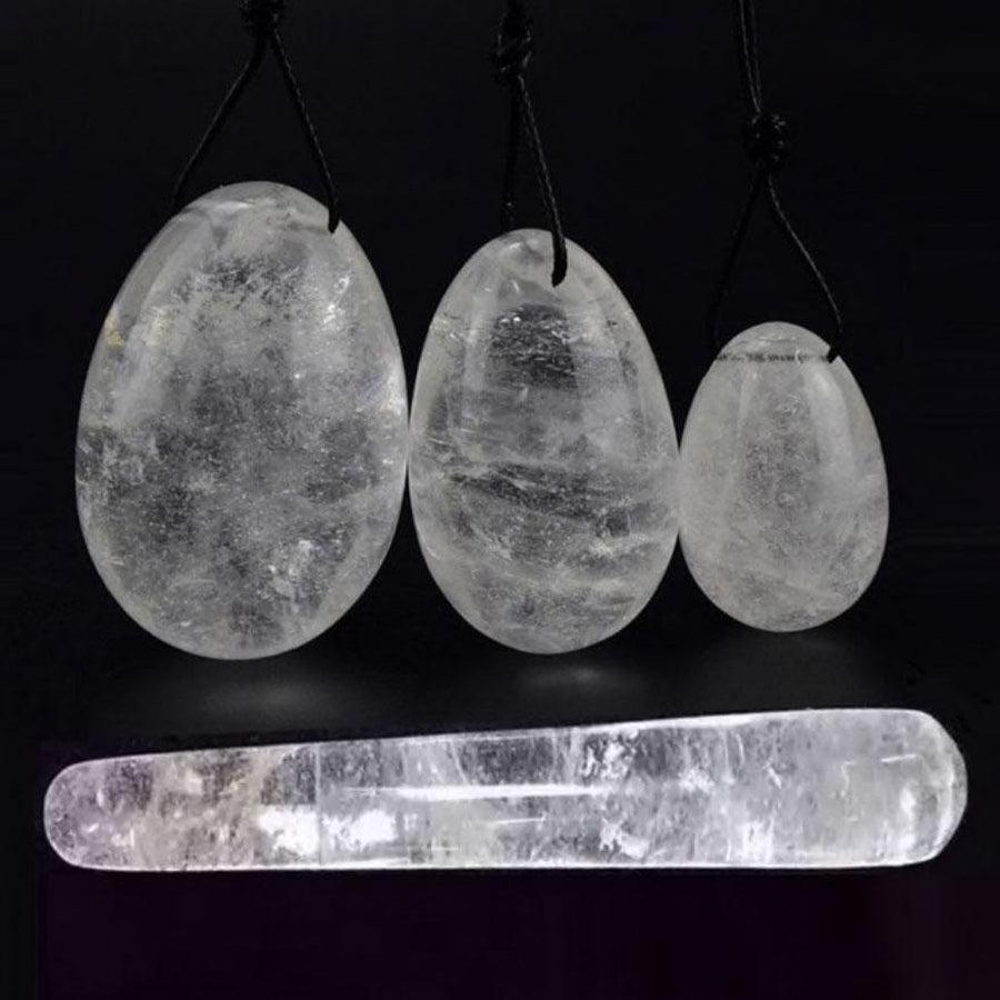 Trois œufs de Yoni en cristal de roche sur fond blanc