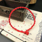 Gros plan sur un bracelet rouge tressé avec nœud ajustable