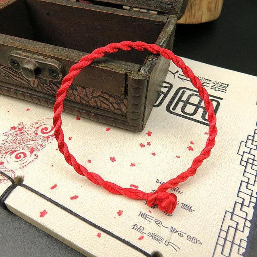 Gros plan sur un bracelet rouge tressé avec nœud ajustable