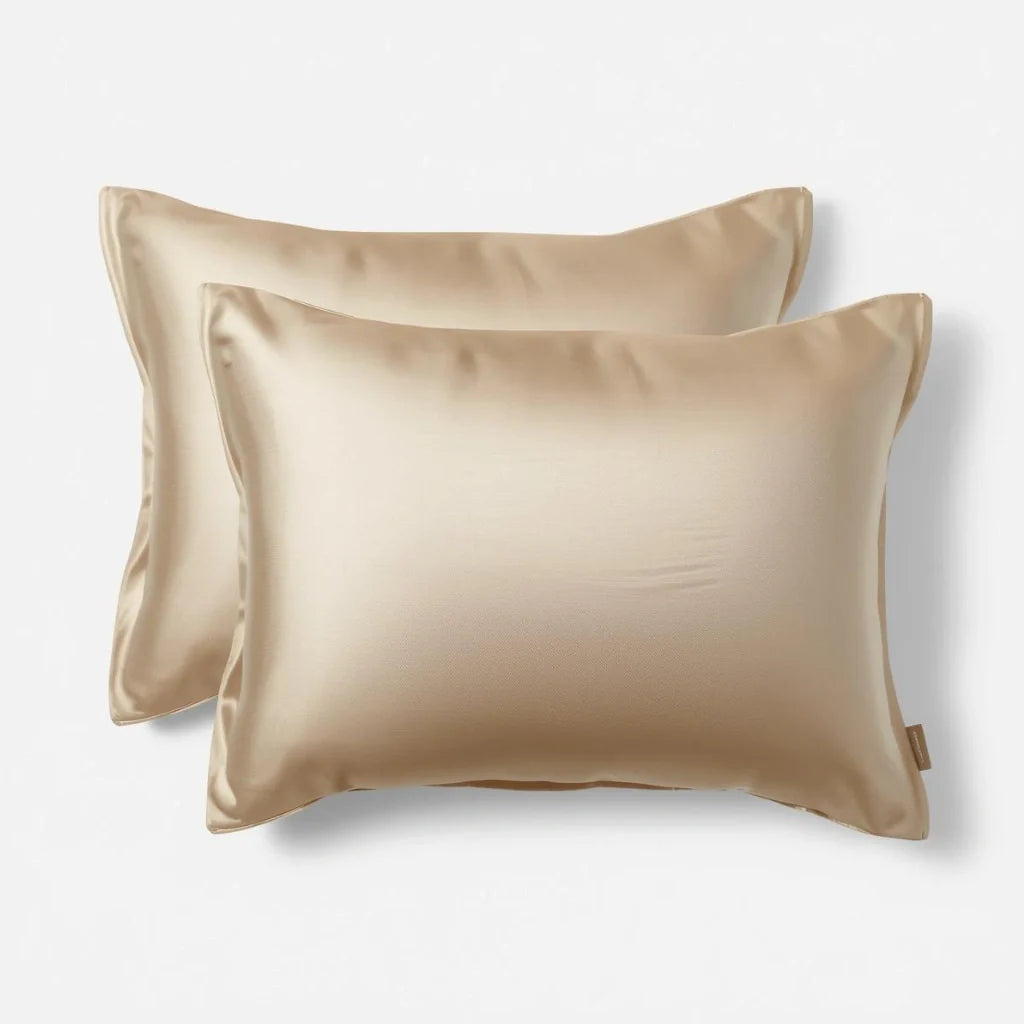Deux taies d'oreiller en soie beige sur lit