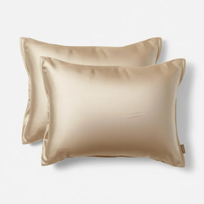 Deux taies d'oreiller en soie beige sur lit