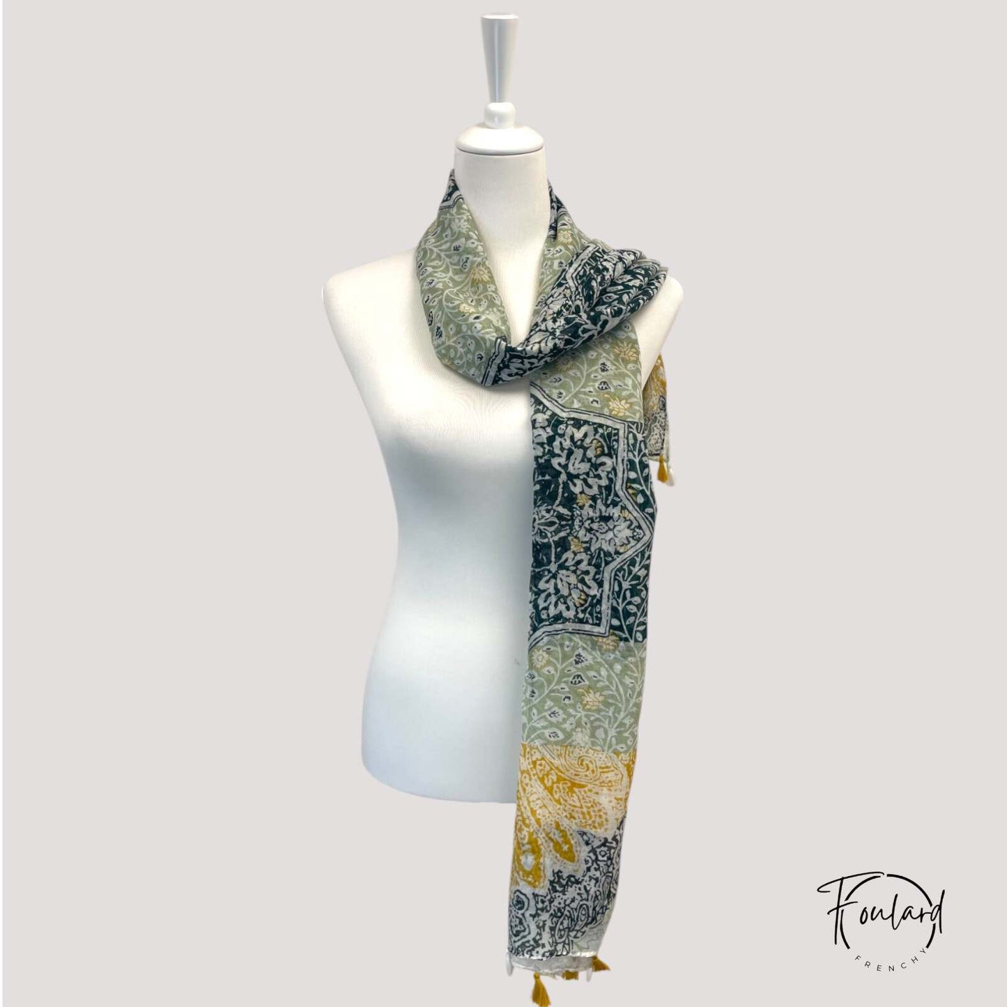 Détail des pompons bohèmes sur le foulard vert