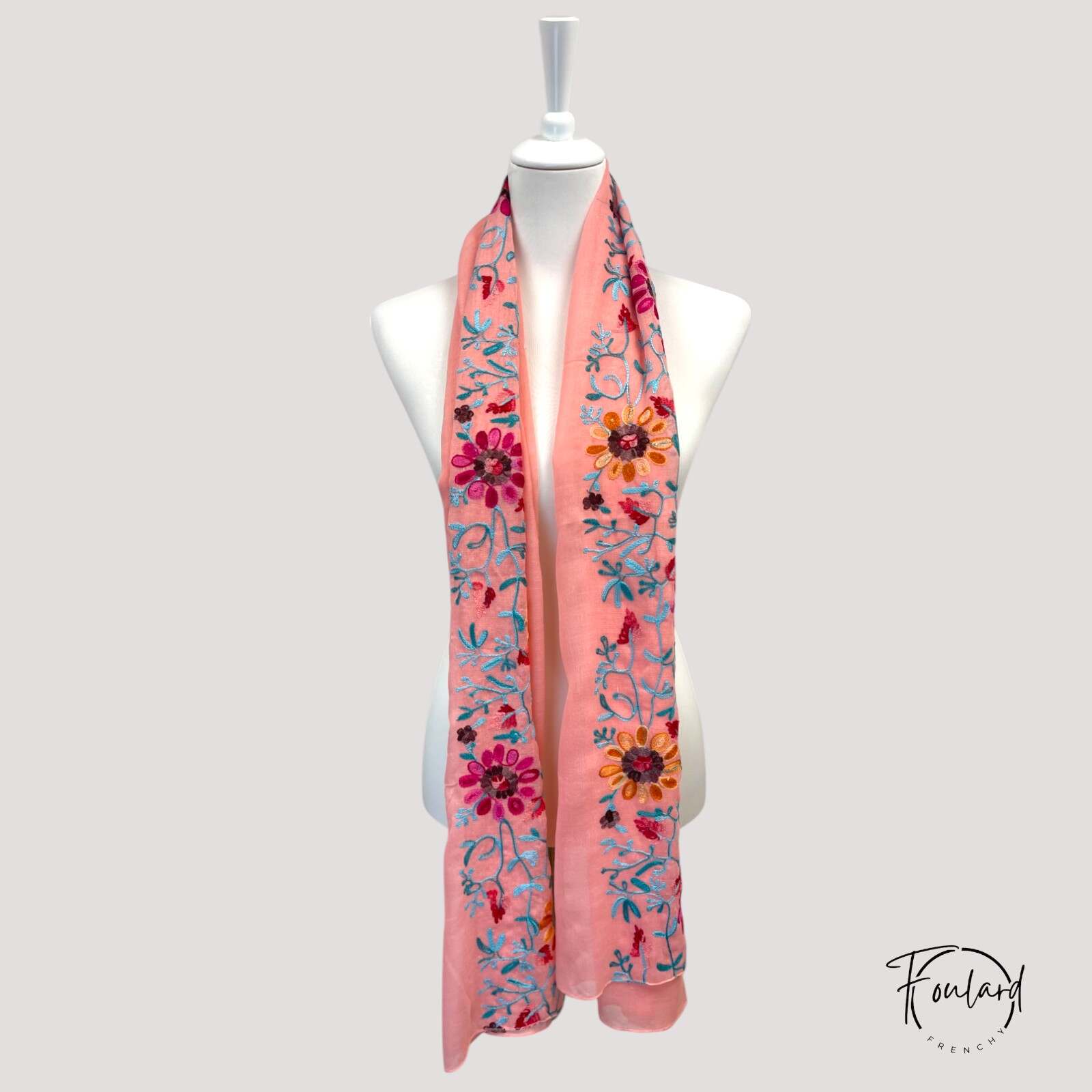 Détail des broderies artisanales sur foulard rose