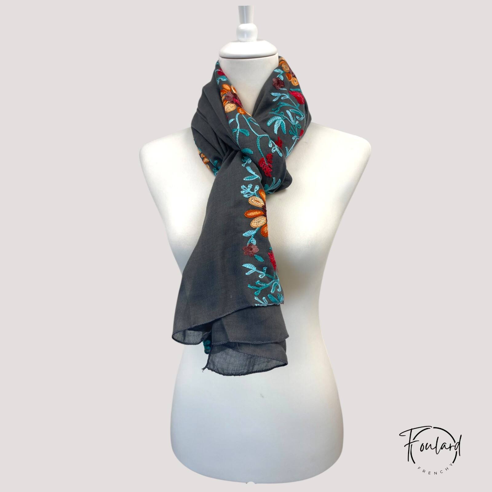 Foulard porté en étole, montrant les broderies vives