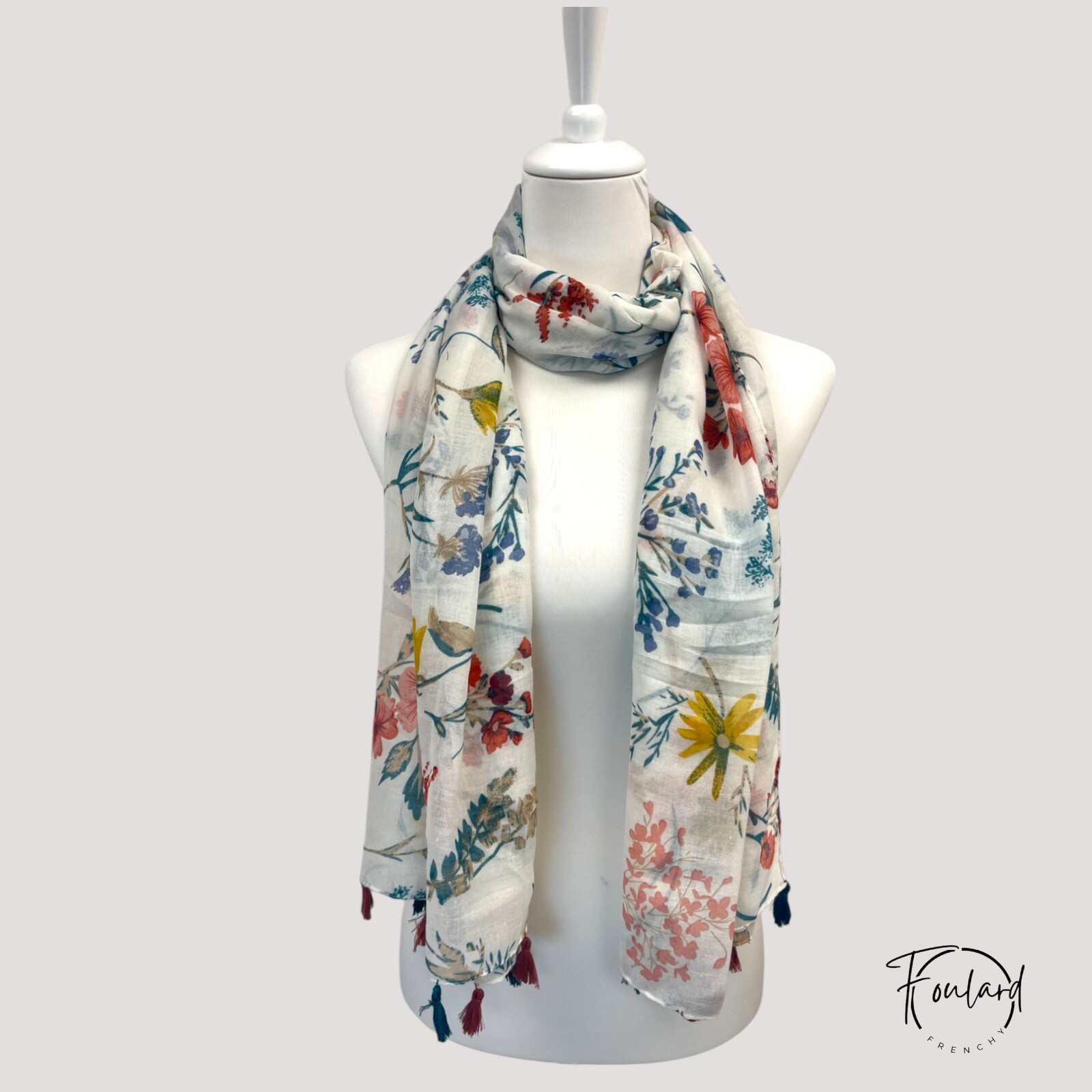Foulard blanc avec pompons frangés sur fond uni