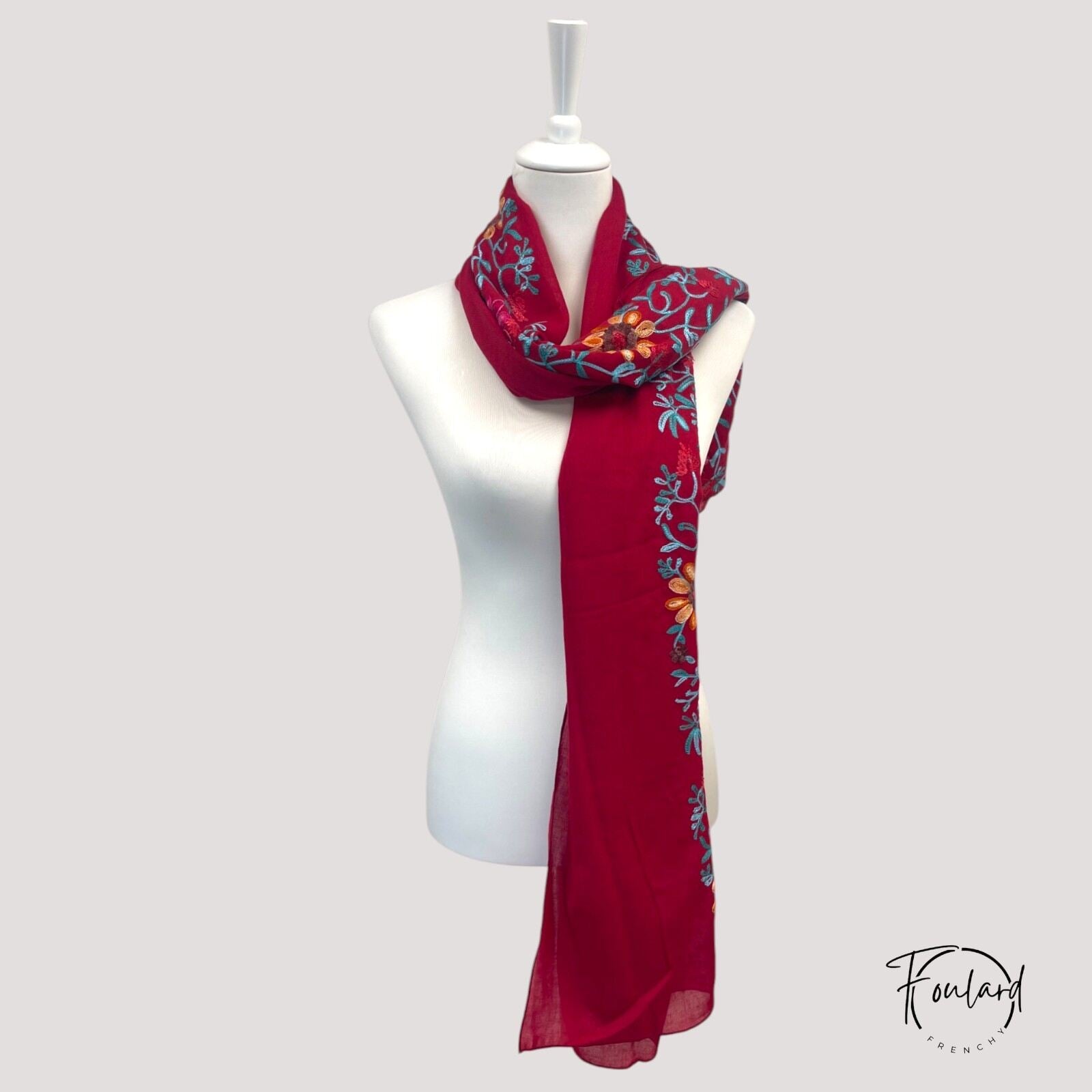 Détail des broderies florales sur tissu léger multicolore