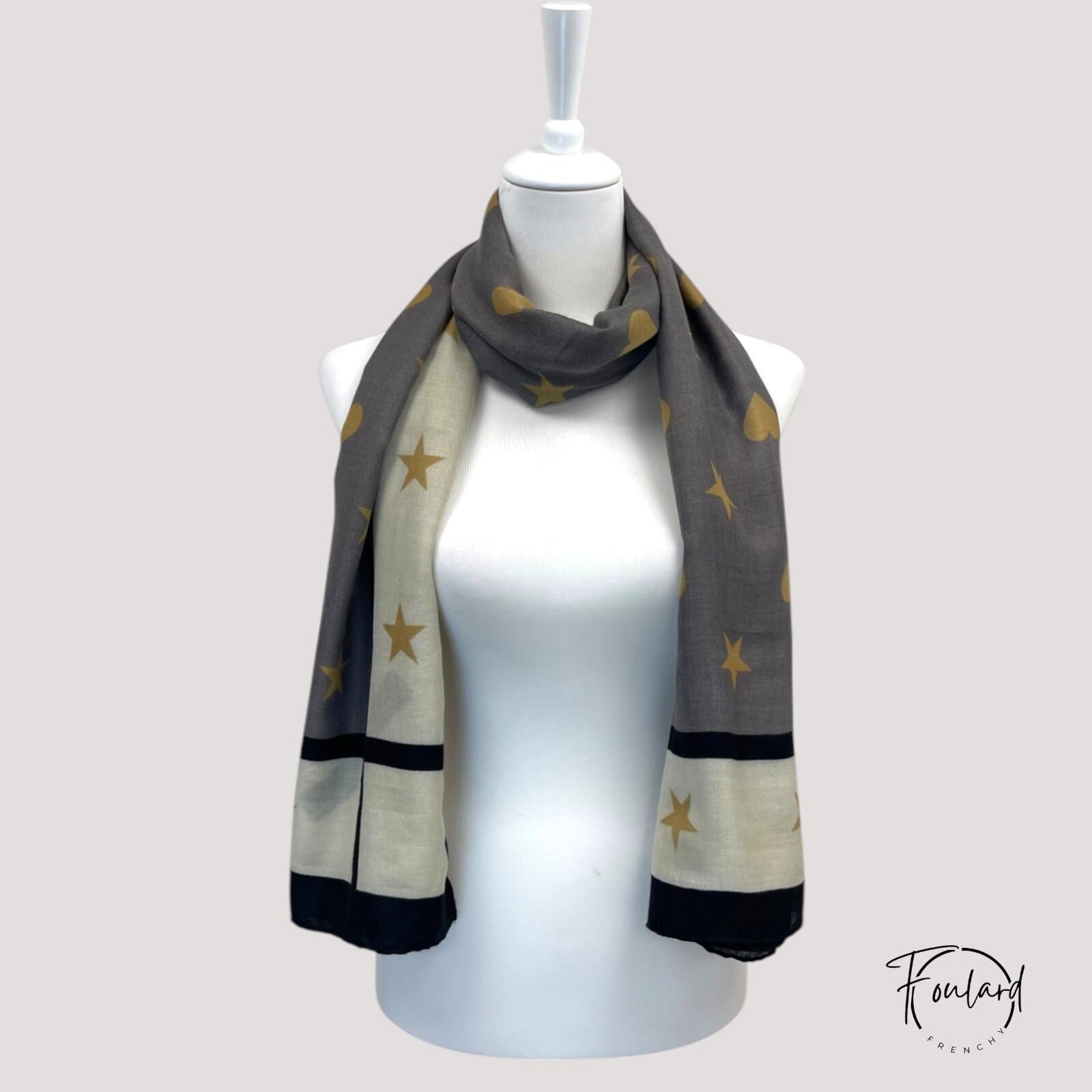 Foulard noir enroulé, mettant en avant sa longueur