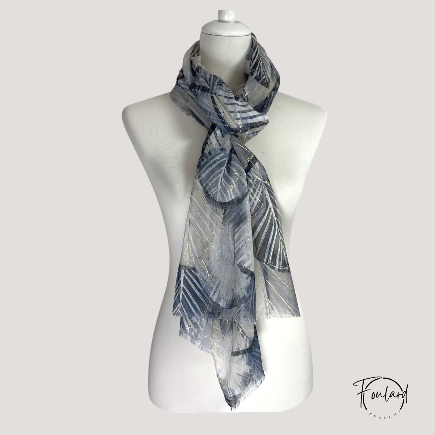 Texture douce du foulard noir, détails dorés visibles
