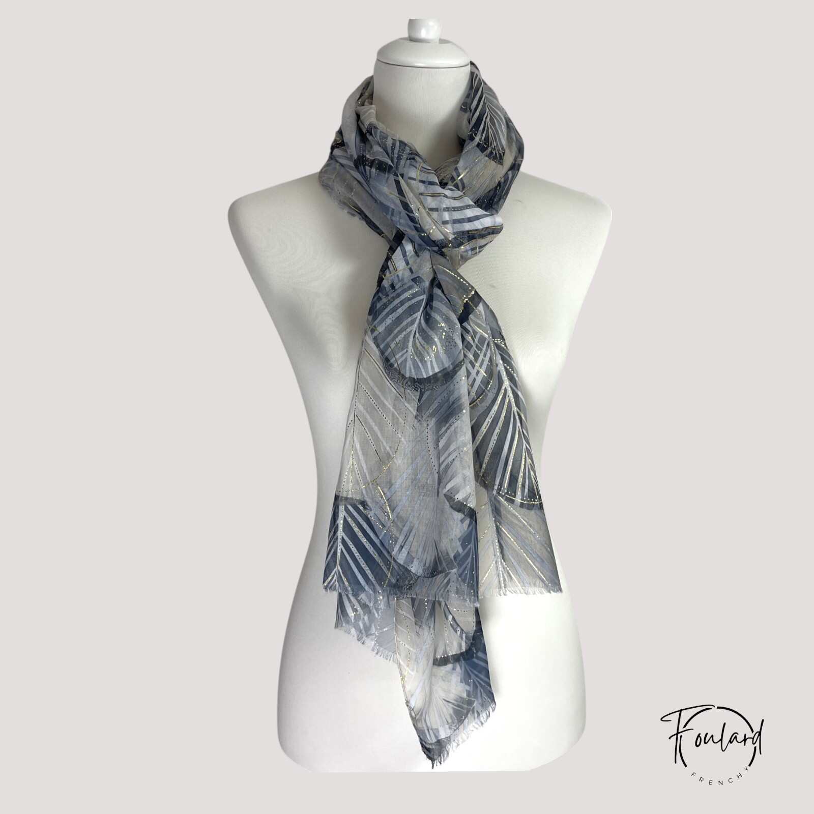 Texture douce du foulard noir, détails dorés visibles