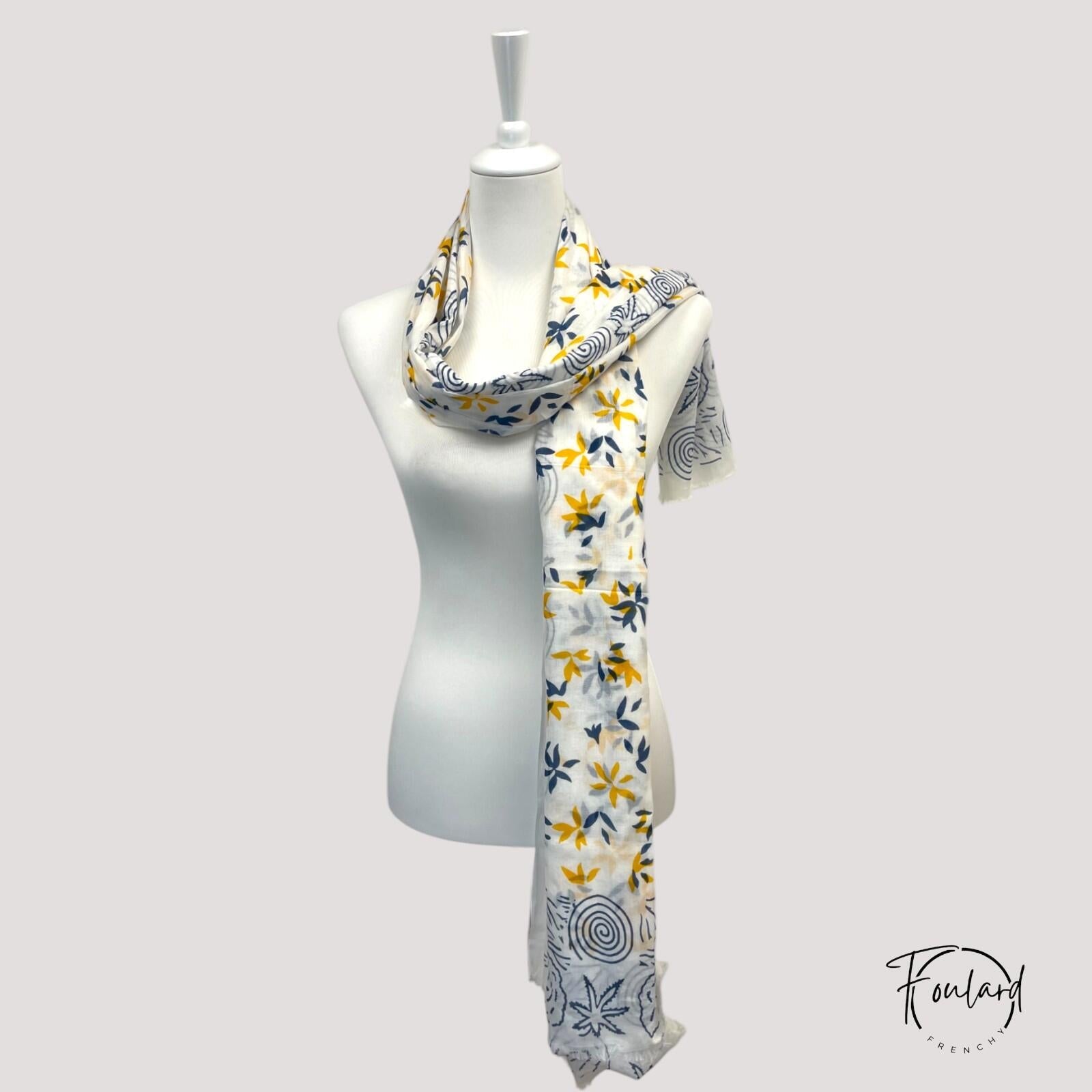 Détail motifs floraux jaunes sur foulard blanc